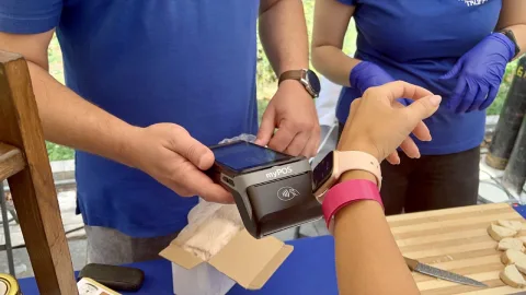 Bezoeker met festivalbandjes betaalt contactloos op een myPOS Carbon pinapparaat