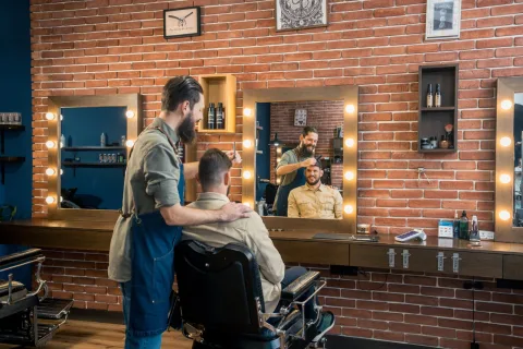 Barbier rekent af met een klant op een myPOS pinapparaat in een barbershop