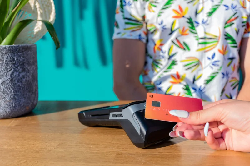 Klant houdt een creditcard bij een myPOS Carbon pinapparaat op de bar